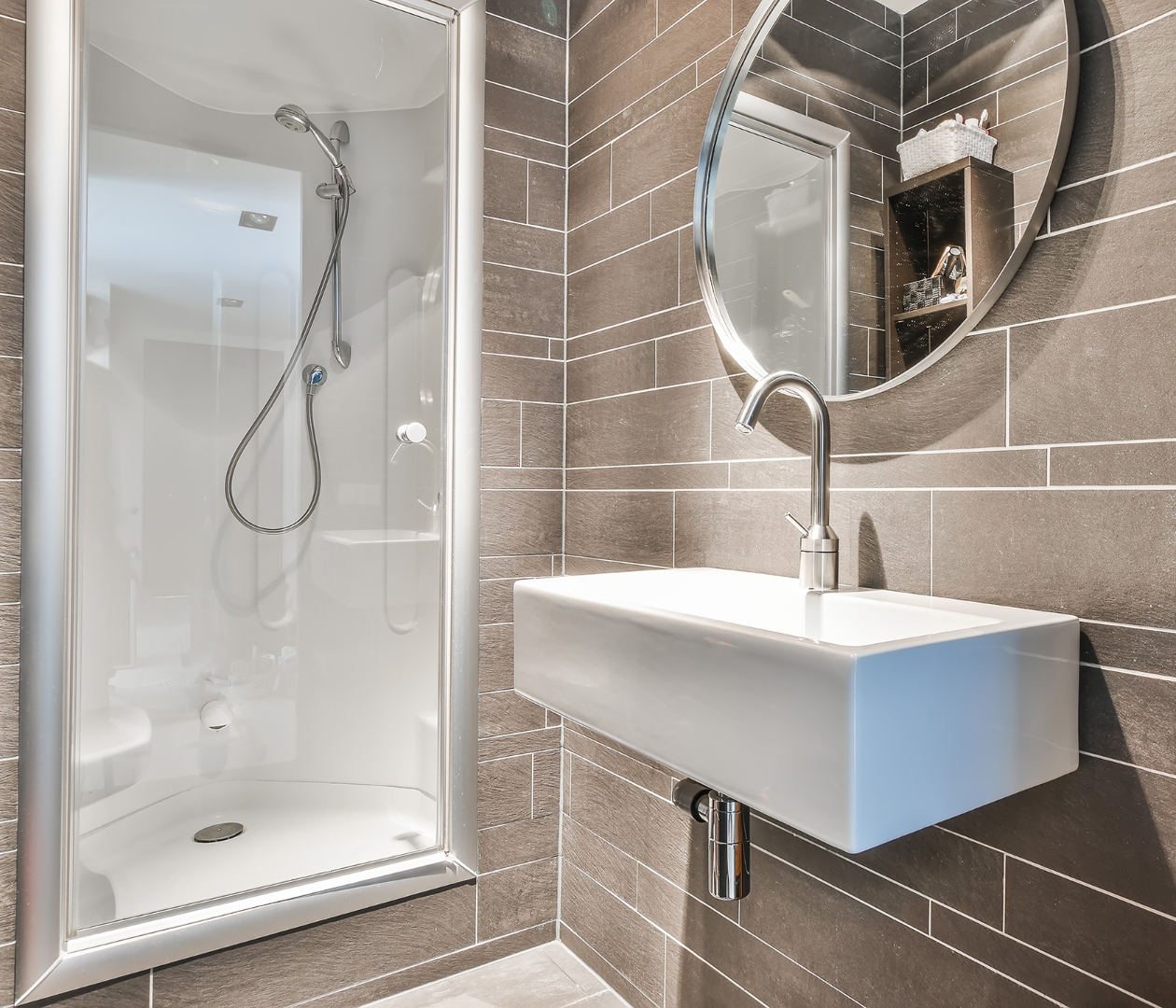 Elegant bathroom with dark tile and wall-mount sink