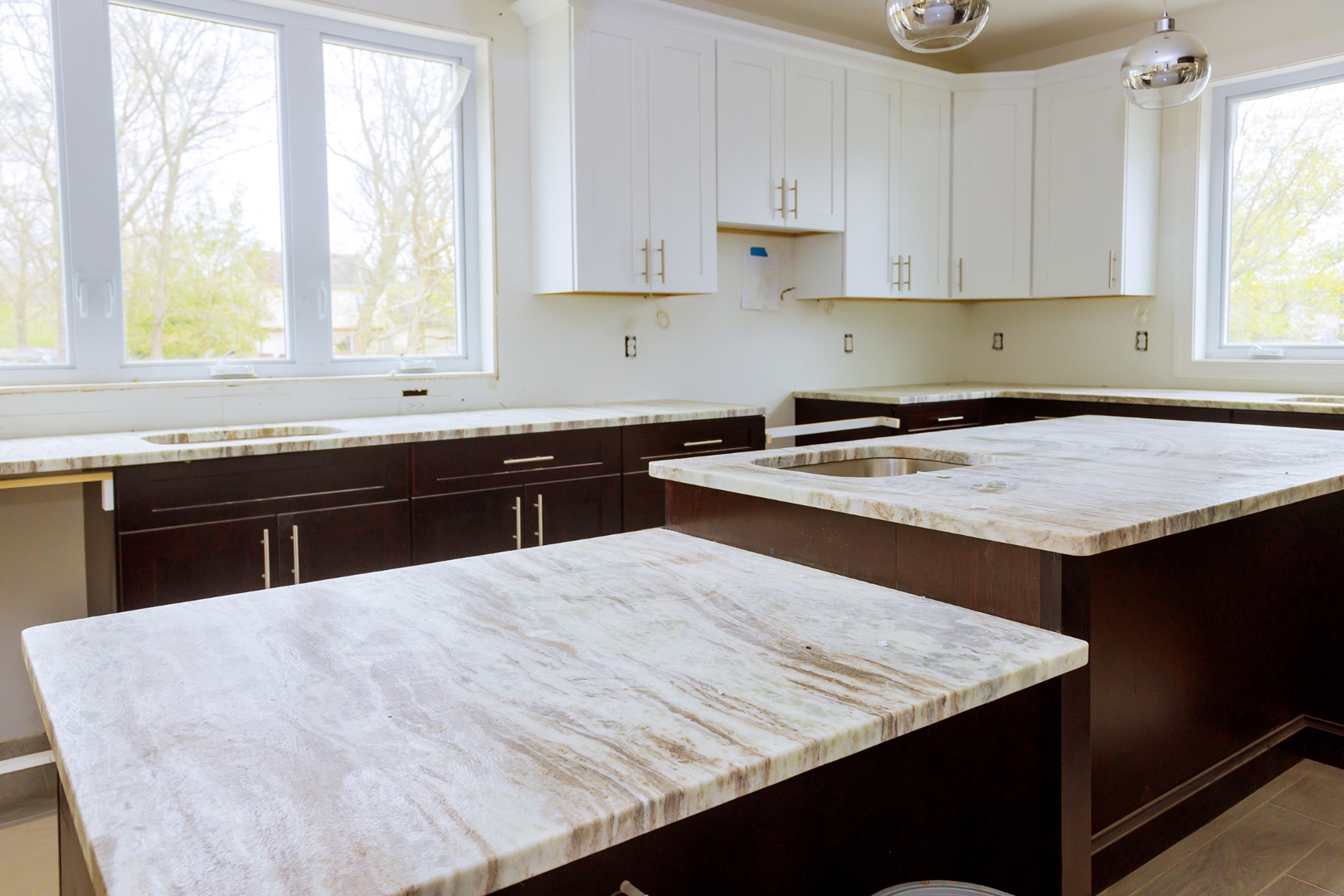 Light stone countertops on dark lower cabinets